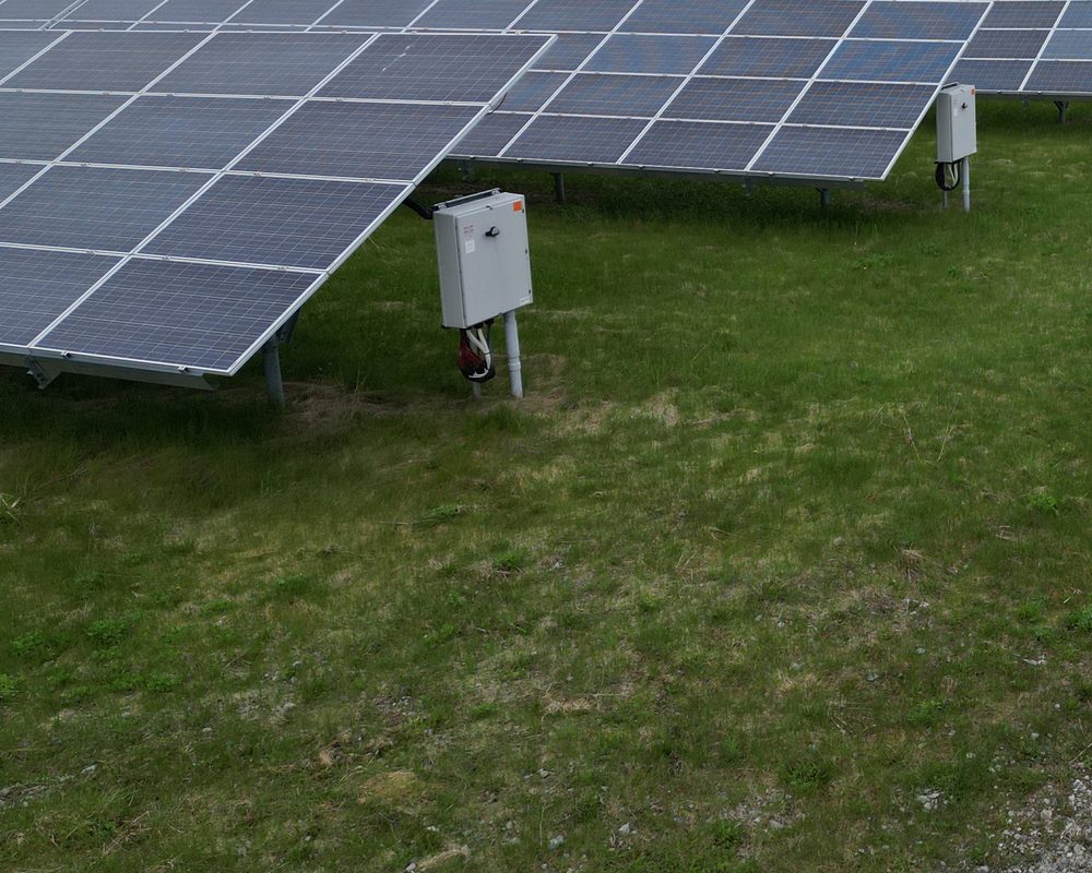 Close view of installed modules and combiner boxes at ground level